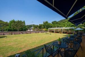 a group of tables and chairs in a field at Suncheon raon house egyeon pension in Suncheon