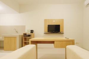 a living room with a table with a tv on it at RedLiving Star Apartemen Semarang - UMAKU Lantai 16 in Jomblang