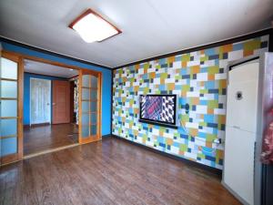 a living room with a wall with colorful tiles at Ahnmyeondo green house in Chaphwa-gol