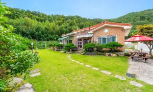 庆州Kyeongju The Hue Pool Villa的一个带长凳和遮阳伞的庭院