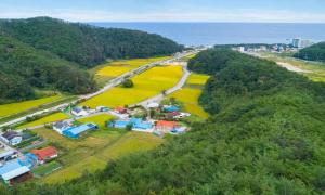 庆州Kyeongju The Hue Pool Villa的海边山上村庄的鸟瞰图 更多6张照片