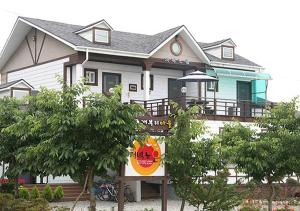 a house with a sign in front of it at Anmyeondo Jeonyeok Noeul Pension in Wŏlgoji