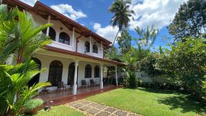 una vista exterior de una casa con patio en Rock House Villa, en Kandy