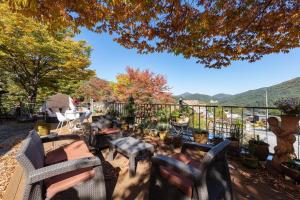 a patio with chairs and tables and a view of the mountains at Gapyeong Morning Calm Pension in Gapyeong +18 photos