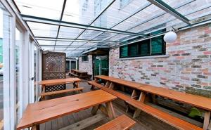a row of wooden benches in a room with a brick wall at Daecheon sinhwa pension in Boryeong