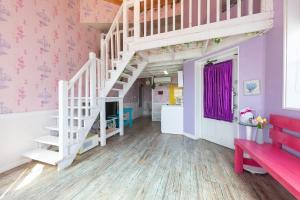a childs room with pink and white walls and stairs at Gwanghwa Concert Pension in Incheon