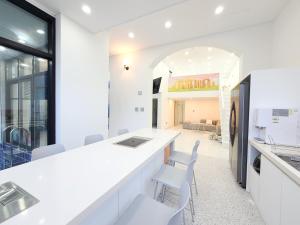 a kitchen with white counters and white chairs at Gapyeong Turu Kids Poolvilla in Gapyeong