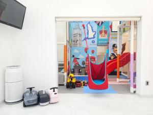 a childrens play room with a slide and swings at Gapyeong Turu Kids Poolvilla in Gapyeong