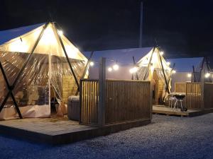 a group of tents with lights in the night at boeun ilsanghwa gramping in Ch'ŏngch'ŏl-li