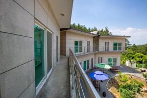 a balcony of a building with a blue umbrella at Taean Scenic Pension in Taean