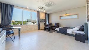 a bedroom with a bed and a desk in a room at Gangneung Hygge Nobile Pension in Gangneung