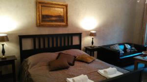 - une chambre avec un lit, un canapé et une chaise dans l'établissement Apartments Rose Garden, à Děčín