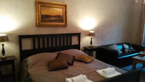 a bedroom with a bed and a couch and a chair at Apartments Rose Garden in Děčín