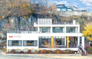 una casa blanca en la cima de una montaña en Ganghwa Cafe Pension Amote, en Incheon
