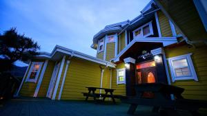 a yellow house with a picnic table in front of it at Buan lemon terrace pension in Buan