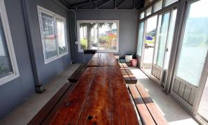 una gran mesa de madera en una habitación con ventanas en Aquapia House, en Taean 10 fotos más