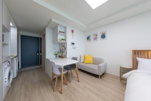 a room with a bed and a table and a couch at Sokcho Rianvichae Central in Sokcho