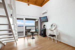 a living room with a staircase and a table and chairs at anmyeondo gold hue pension in Taean +25 photos