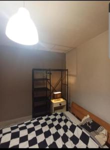 una camera con un letto a scacchi bianco e nero di Chambre Pessac proche rocade aéroport a Pessac