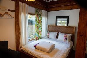 a bedroom with a bed with a wooden headboard and a window at Luwa Private Pension in Jeonju