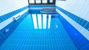 - une piscine revêtue de carrelage bleu dans l'établissement Gyeonju Coo n eye kids poolvilla, à Gyeongju 29 autres photos