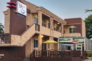 a building with tables and umbrellas in front of it at Anmyeondo Noeul Shimteo Pension in Chŏkkae