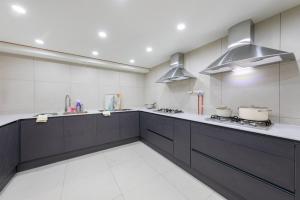 a large kitchen with black and white cabinets and appliances at Gangneung Stay in Gangneung in Gangneung