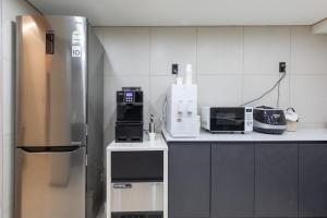 a kitchen with a stainless steel refrigerator and appliances at Gangneung Stay in Gangneung in Gangneung +7 photos