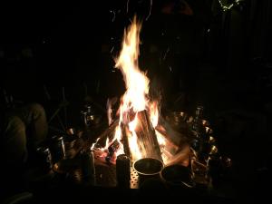 a fire in the dark with pots and pans around it at Yangpyeong Why Glamping in Yangpyeong