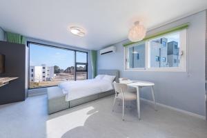 Ένα ή περισσότερα κρεβάτια σε δωμάτιο στο Gangneung Stay Today