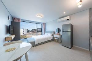 Ένα ή περισσότερα κρεβάτια σε δωμάτιο στο Gangneung Stay Today