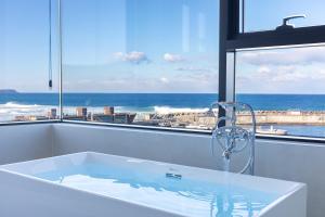 a bath tub with a view of the ocean at Donghae Staypear471 in Donghae +13 photos