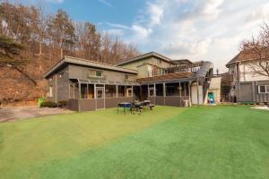a large house with a lawn in front of it at Free Time Pension Gapyeong in Gapyeong