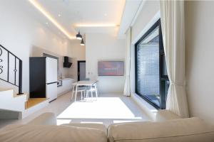 a living room with a couch and a large window at Gangneung Gyeongpo 345 Pool Villa in Kyŏngp'o-mal