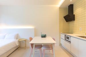 a bedroom with a bed and a table and chairs at Gangneung Gyeongpo 345 Pool Villa in Kyŏngp'o-mal +12 photos