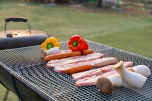 a grill with hot dogs and vegetables on it at Free Time Pension Gapyeong in Gapyeong +14 photos