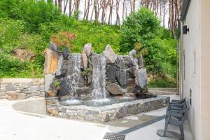 une fontaine à eau au milieu d'une cour dans l'établissement Gangneung Ranteuruhe Pension, à Gangneung