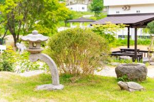 a stone birdbath in a garden with a park at Ganghwa Bridge House in Incheon