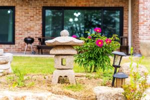 a garden with a bird house with a hat on it at Ganghwa Bridge House in Incheon +32 photos