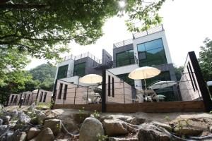 ein Haus mit zwei Sonnenschirmen davor in der Unterkunft Yeongwol Hieori Pension in Yeongwol