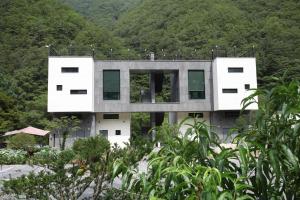 ein Gebäude mit grünen Rollläden auf einem Berg in der Unterkunft Yeongwol Hieori Pension in Yeongwol