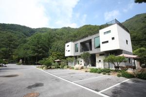 ein großes weißes Gebäude mit einem Parkplatz in der Unterkunft Yeongwol Hieori Pension in Yeongwol