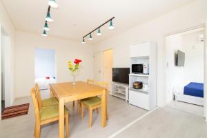 una sala da pranzo con tavolo, sedie e un letto di レジーナ石垣 アクアステージ Regina Ishigaki Aqua stage a Isola di Ishigaki