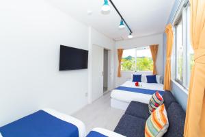 una camera d'albergo con due letti e un divano di レジーナ石垣 アクアステージ Regina Ishigaki Aqua stage a Isola di Ishigaki