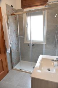 a bathroom with a shower with a glass door at Luciana Apt - 3 min train to FCO Airport & Fiera in Fiumicino +45 photos