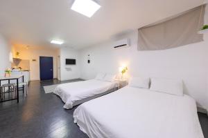 a bedroom with two beds and a kitchen at Goseong Oneul Bada Pension in Goseong
