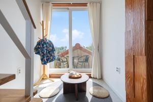 ein Wohnzimmer mit großem Fenster und Tisch in der Unterkunft Gangneung Mirabell Spa Pension in Kyŏngp'o-mal