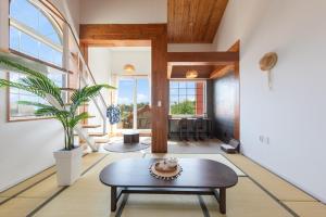 ein Wohnzimmer mit Tisch und großem Fenster in der Unterkunft Gangneung Mirabell Spa Pension in Kyŏngp'o-mal