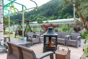 a fire pit on a patio with chairs and a view at Chuncheon Byeol Kkot Soop in Chuncheon