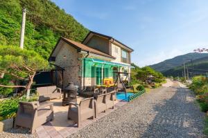 a house on a hill with chairs and a pool at Chuncheon Byeol Kkot Soop in Chuncheon